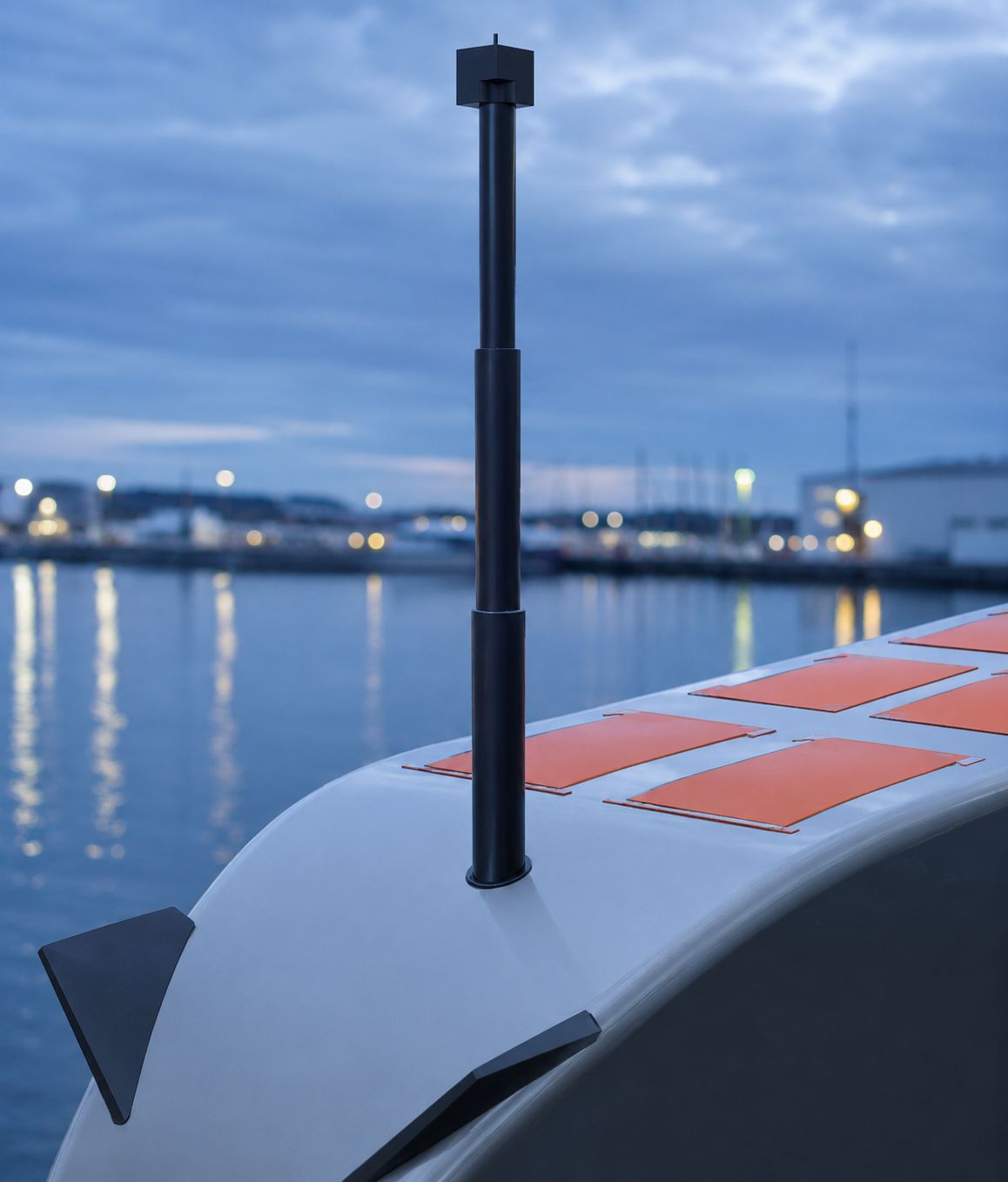 The three-stage mast at full extension against a harbour skyline